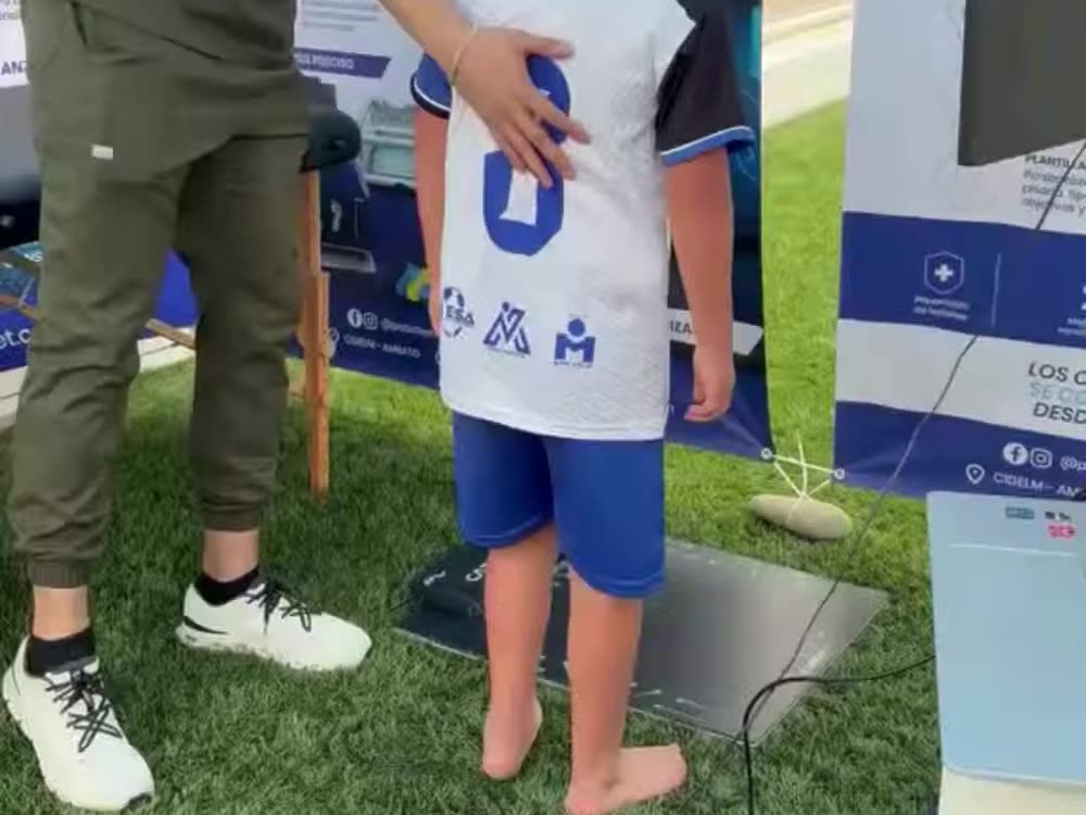 Podólogo de PodoFeet escaneando la pisada de un niño de la academia.