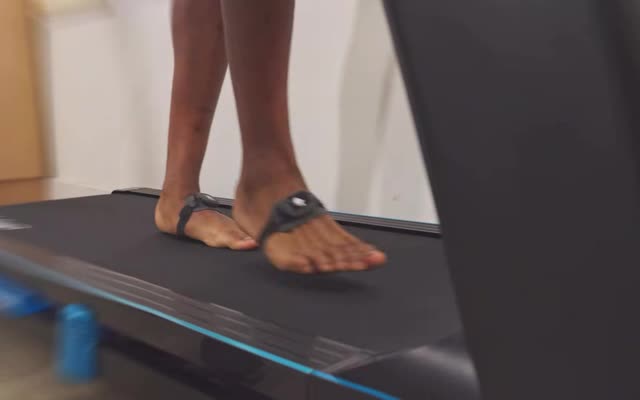 Pies descalzos caminando sobre la trotadora de medición.